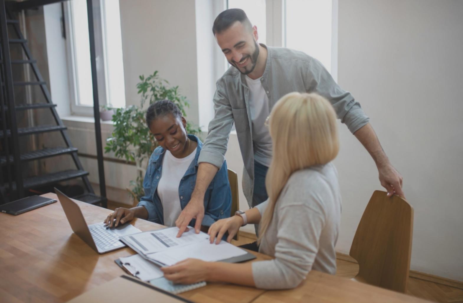 Equipo de trabajo colaborando en análisis financiero con documentos y gráficos